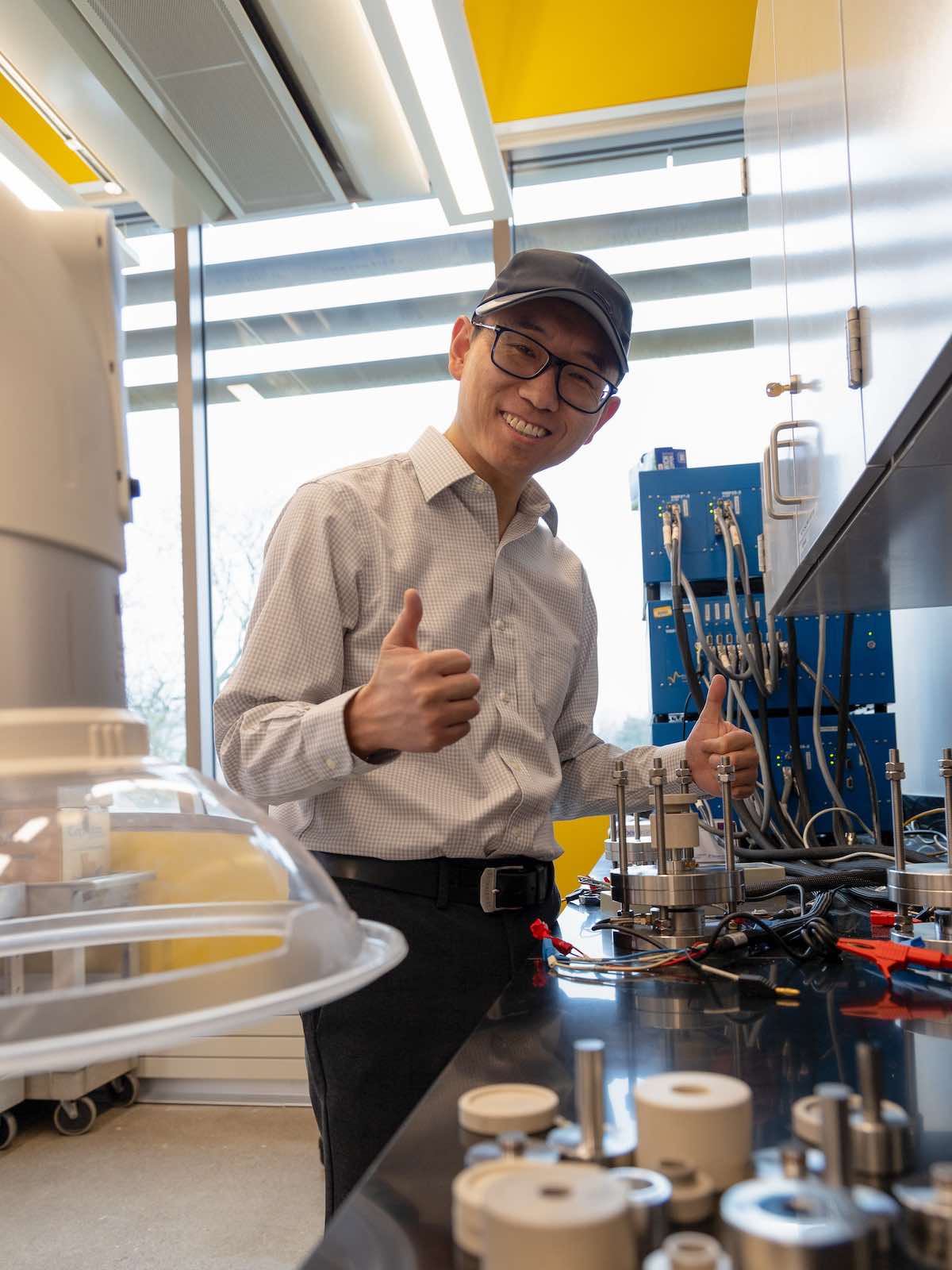 Associate Professor Xuan Zhou gives a double thumbs up in his battery lab