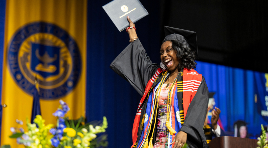A UM-Dearborn graduate walks across the stage at the Spring 2024 commencement ceremony.